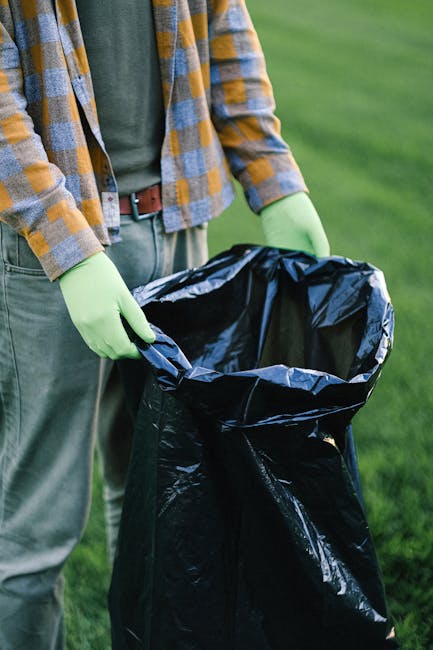 The image shows the rear section of a white commercial van parked on a paved street, with three large blue rubbish bags placed on the ground beside it. The bags are made of thick plastic material, sli